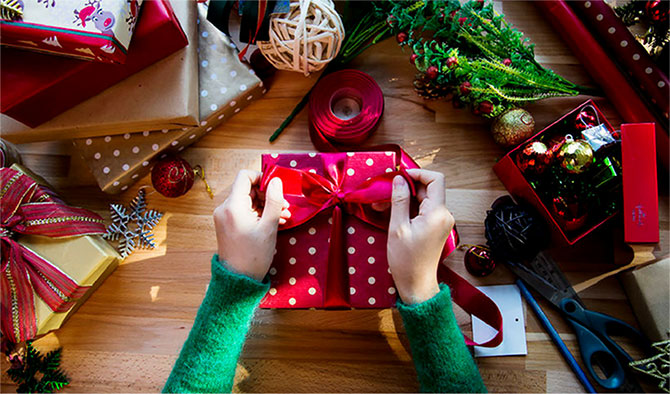 A table filled with wrapped gifts and wrapping essentials.